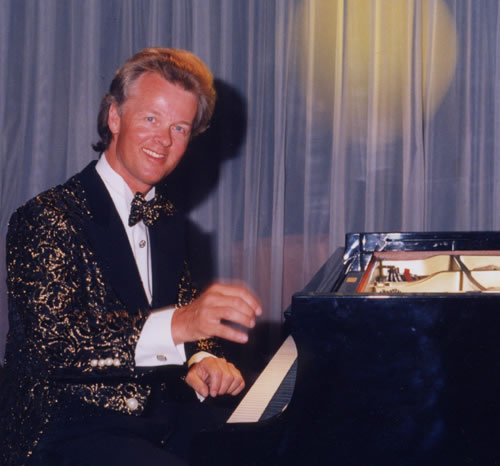 Jon England at grand piano on stage